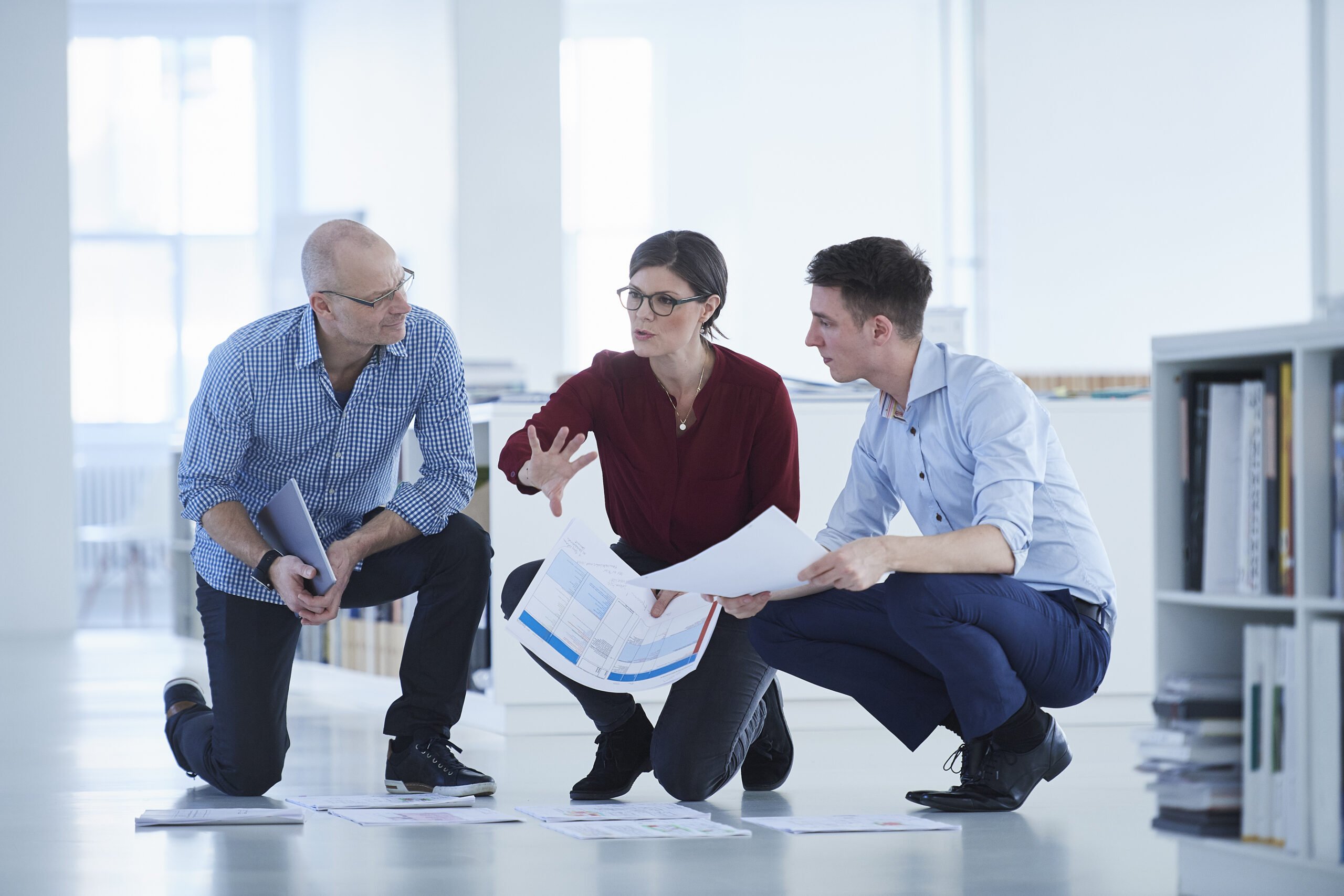 Colleagues working in office looking at blueprints